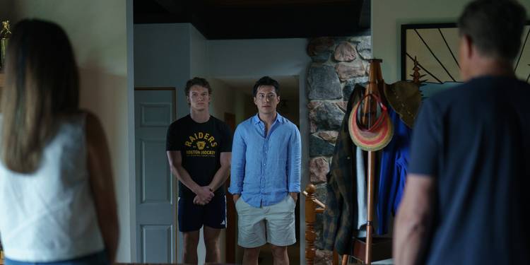 Connor Storrie and Hudson Williams staring ahead at other people in the Heated Rivalry Season 1 finale.