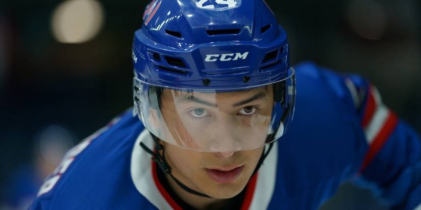 Hudson Williams as Shane Hollander in hockey gear, looking up with intensity on 'Heated Rivalry.'