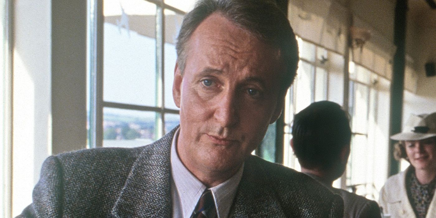 Hugh Fraser in a restaurant looking seriously ahead in Poirot.