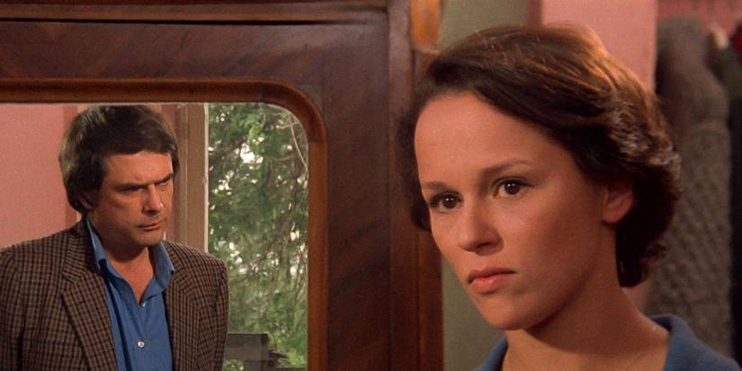 A man's reflection on the mirror looking at a woman in Identification of a Woman