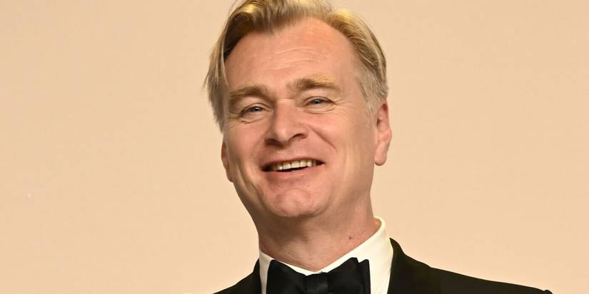 Christopher Nolan in a tuxedo and bow tie smiling.