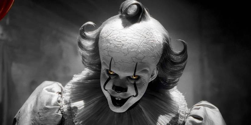 Pennywise grinning in a black-and-white flashback in IT: Welcome to Derry