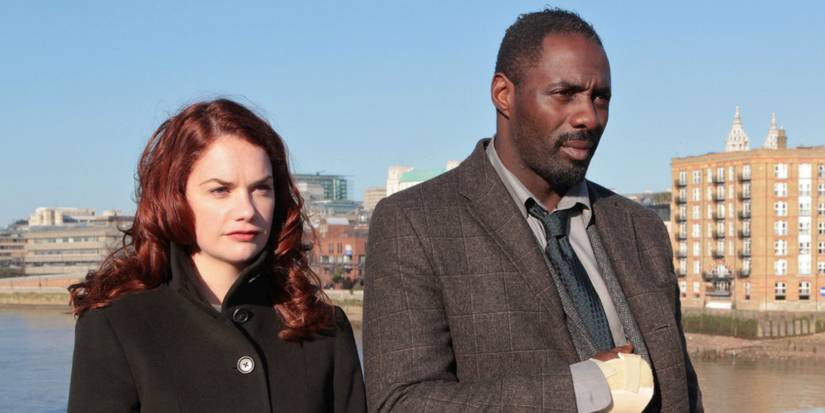 Ruth Wilson and Idris Elba looking in the same direction with a city behind in Luther.