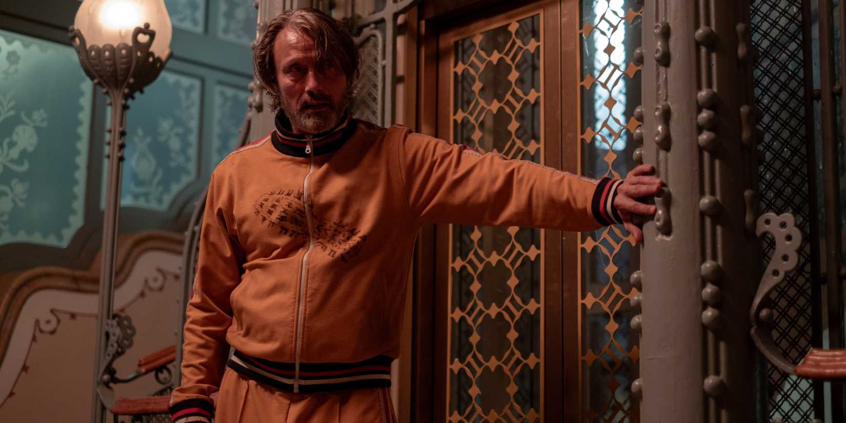 Mads Mikkelsen as Intriguing Neighbor reaching out to push the elevator button in Dust Bunny
