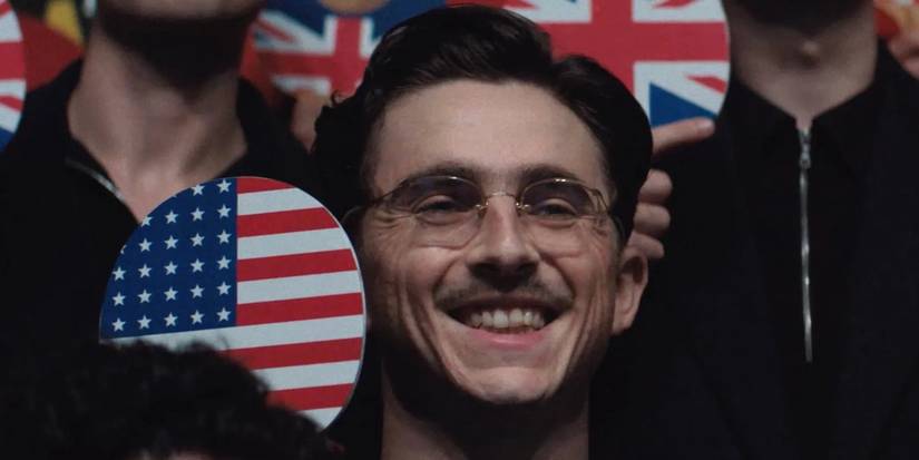 Timothée Chalamet smiling in a crowd in Marty Supreme