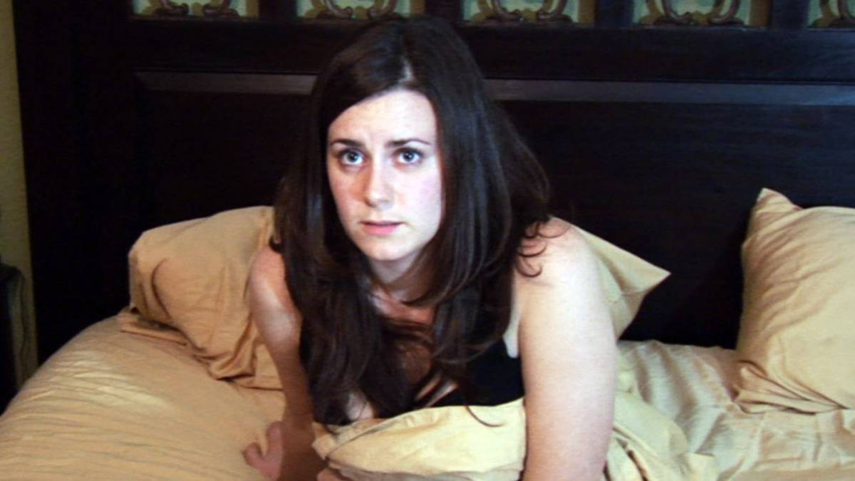 Kate Featherston lying on a bed in Paranormal Activity