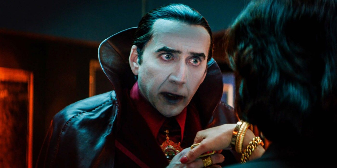 Dracula (Nicolas Cage) takes a woman's hand and looks her in the eyes in Renfield