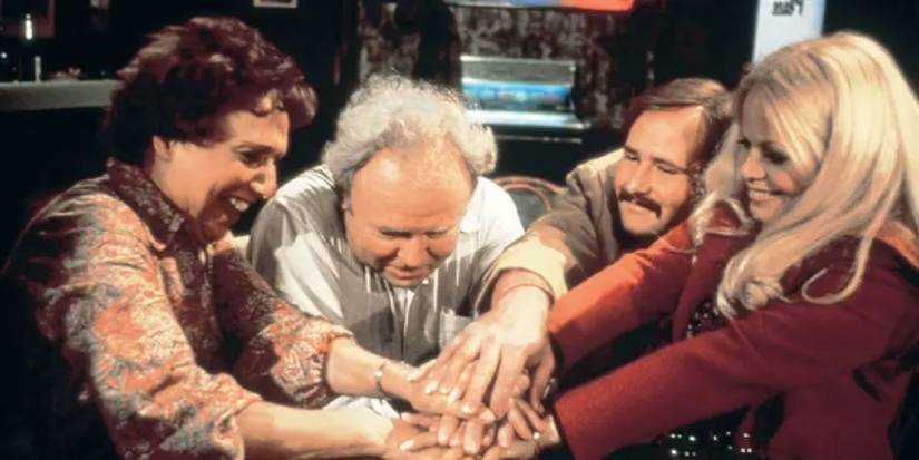 The Bunker family putting all their hands in together in All In the Family.
