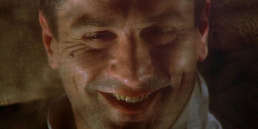 Robert De Niro as Noodles smiling at the camera in the final shot of Once Upon a Time in America (1984)