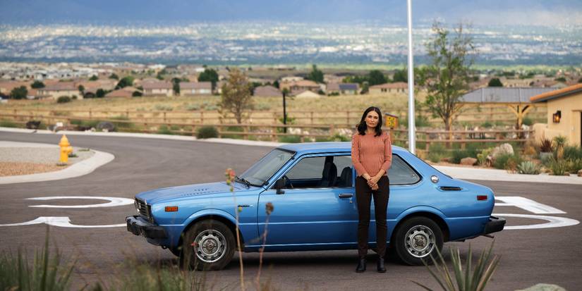 Karolina Wydra leaning against a parked car in Pluribus Episode 7
