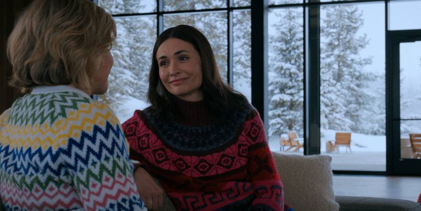 Rhea Seehorn and Karolina Wydra in sweaters talking with a snowy landscape outside in the Pluribus finale.