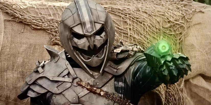 An alien hunter aiming a glowing green futuristic weapon on his wrist in 'Predator: Wastelands' (2025), a ripoff of the Predator franchise. 