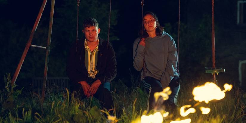 Jon Pointing et Maeve Courtier-Lilley regardent un feu de camp dans les bois la nuit dans Run Away de Harlan Coben.