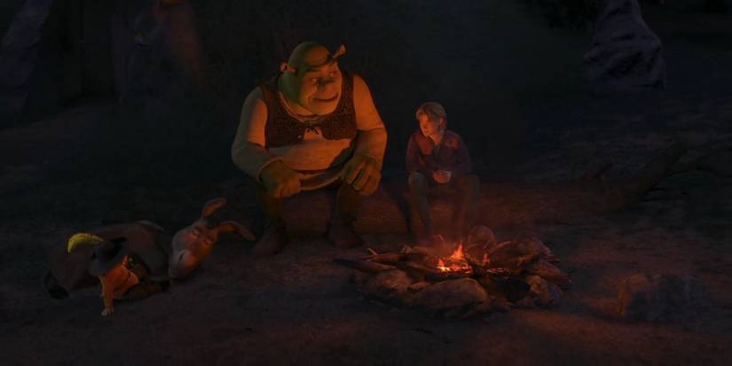 Shrek, Arthur, Puss in Boots, and Donkey, sit around a campfire