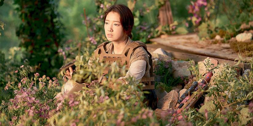Park Shin-hye sentada entre flores em Sisyphus: The Myth