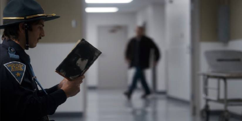 A state trooper reads 'Cujo' by Stephen King during 'Stranger Things' Season 1.