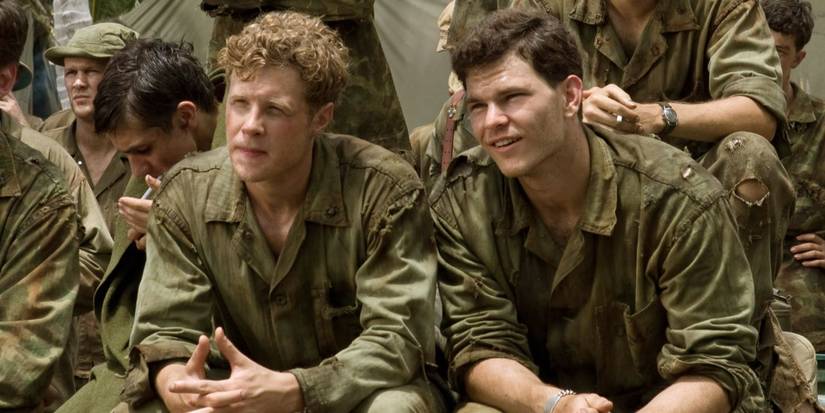 Ashton Holmes and Joshua Helman as soldiers with others sitting and looking ahead in The Pacific.