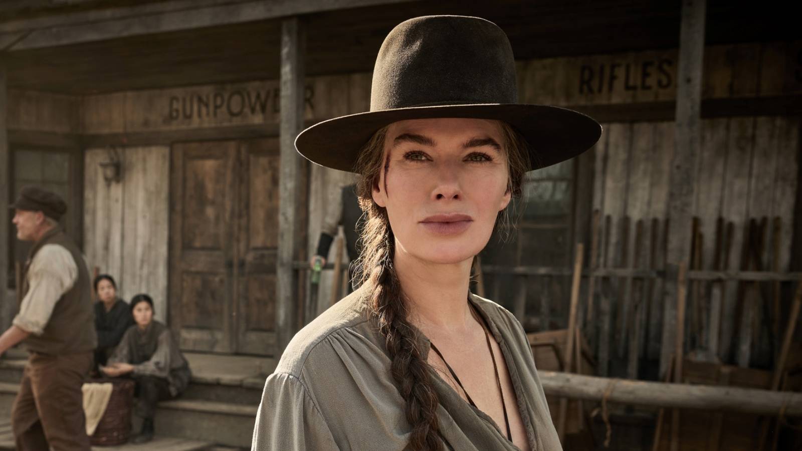 Lena Headey as Fiona Nolan standing in town wearing a cowboy hat in The Abandons