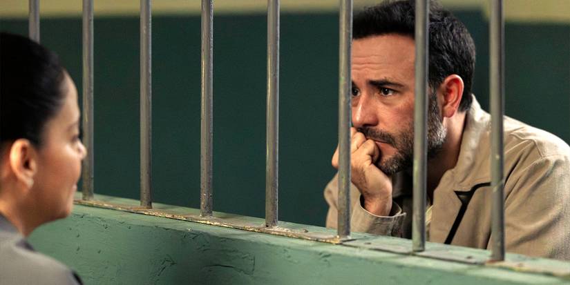 Emiliano Lobo (Sebastián Martínez) talking to Daniela Robles (Ana Claudia Talancón) behind bars in Season 2 of 'The Accident'