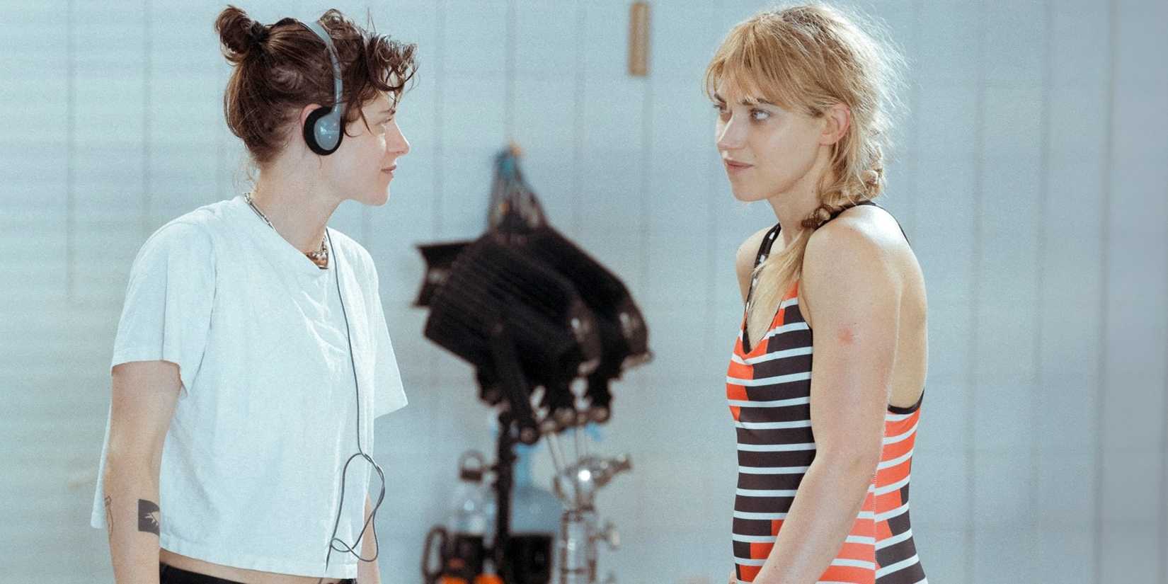 Kristen Stewart wearing headphones and directing Imogen Poots as Lidia on set for The Chronology of Water