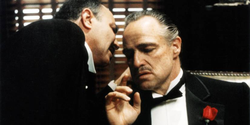 A man whispering into Vito Corleone's ear in The Godfather