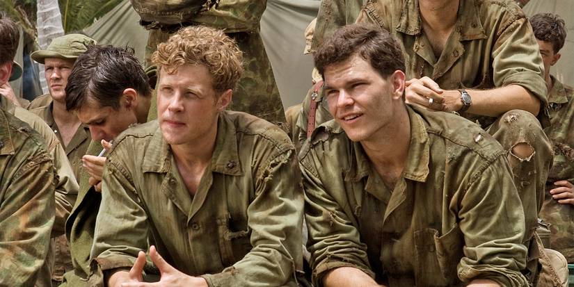 Ashton Holmes and Josh Helman sit among other soldiers, listening to instructions, in The Pacific.  