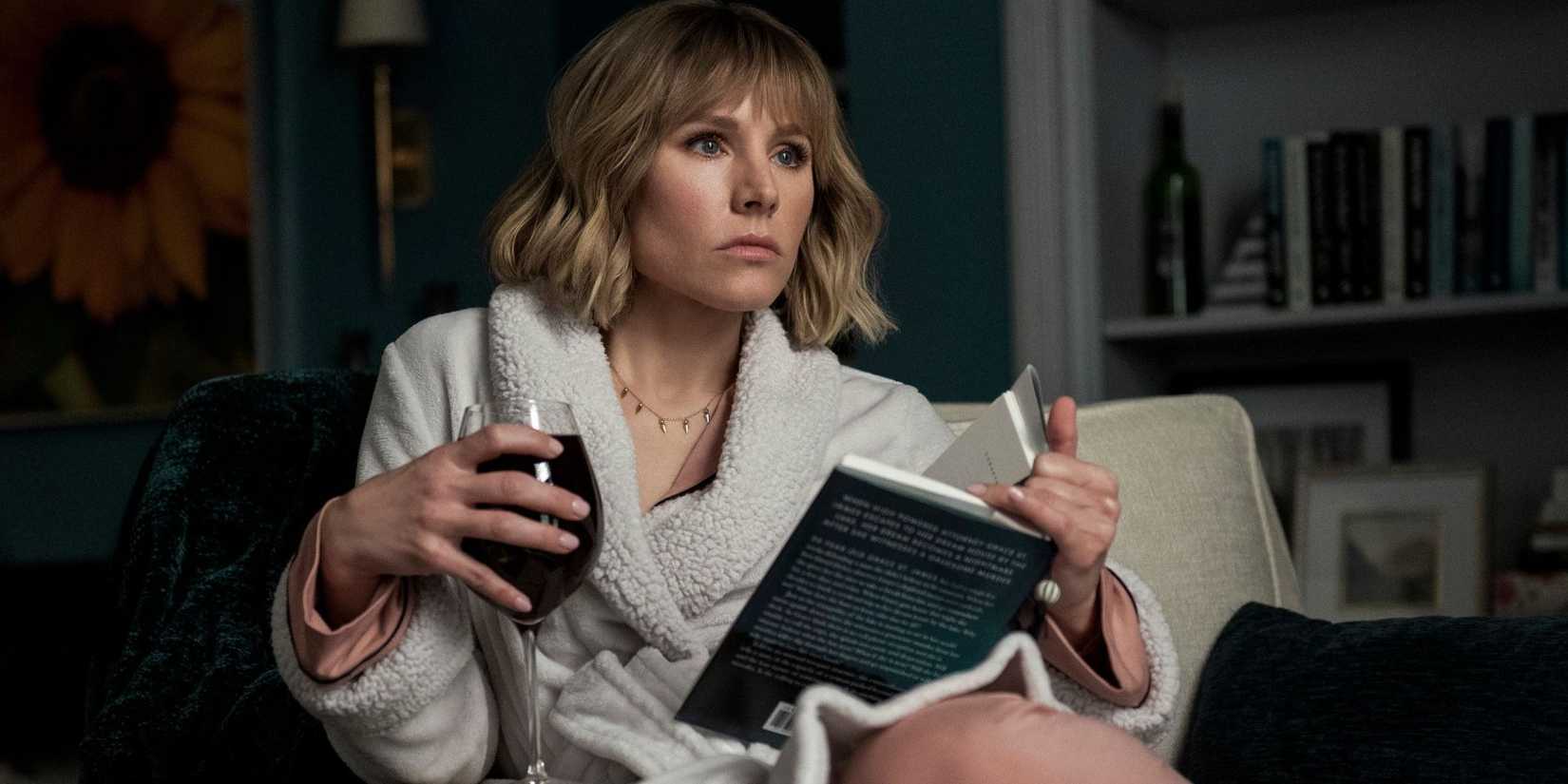 Kristen Bell holds a book and drink in The Woman in the House Across the Street From the Girl in the Window.