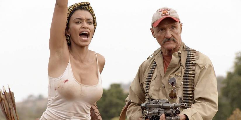 Lucia (Natalie Becker) e Burt (Michael Gross) se preparam para a ação em Tremors 5