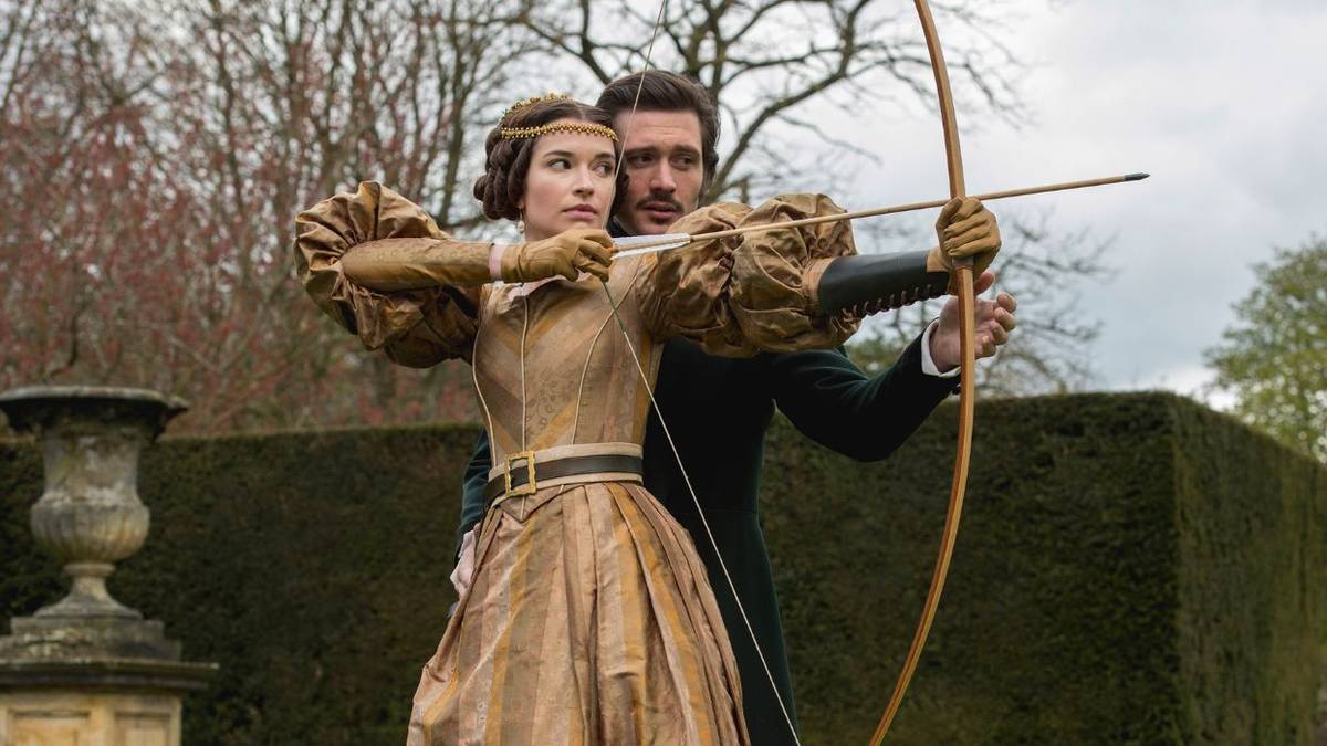 Man and woman in Victorian garb pulling back a bow and arrow