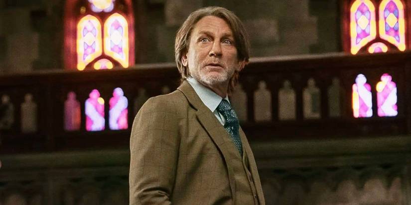 Daniel Craig as Benoit Blanc standing in a church in Wake Up Dead Man.