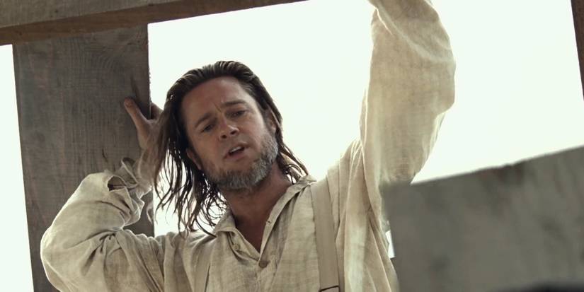 Brad Pitt as Samuel Bass with a beard looking down in '12 Years a Slave.'