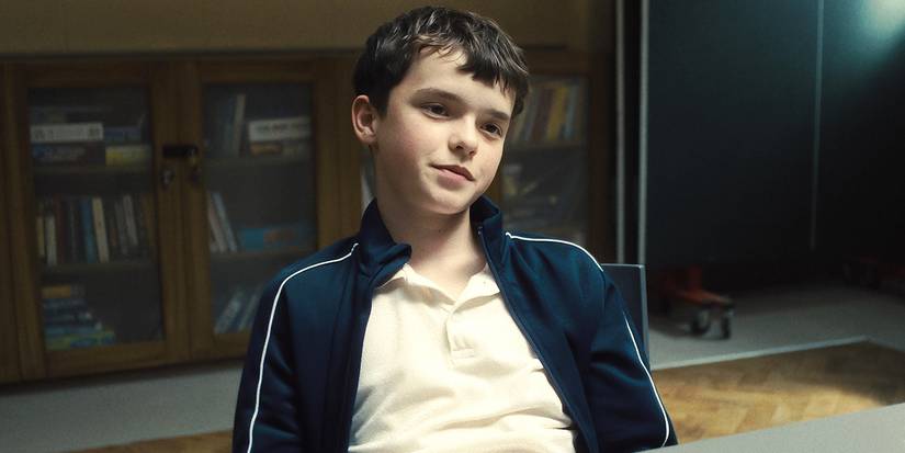 Jamie in a chair with a small smile in Adolescence.
