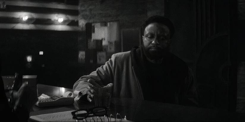 A character sitting in black and white in Wonder Man Episode 4.