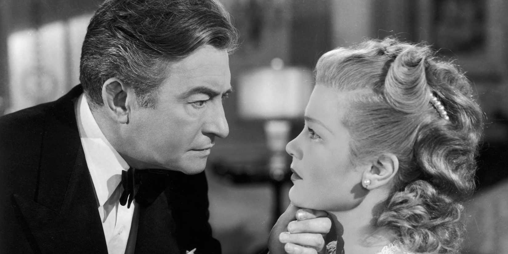 Claude Rains looking at Joan Caulfield with his hand on her chin in The Unsuspected (1947)