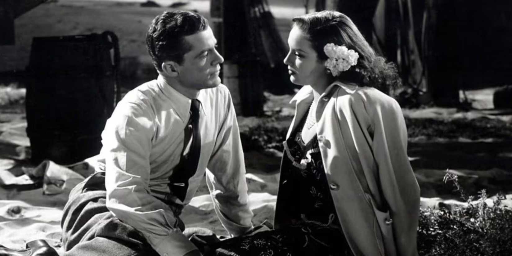 Dana Andrews sitting and looking at Linda Darnell sitting across from him in Fallen Angel (1946)