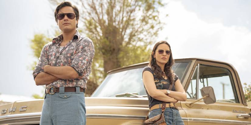 Sgt. Jim Chee (Kiowa Gordon) and Sgt. Bernadette Manuelito (Jessica Matten) leaning against a truck on 'Dark Winds' Season 4