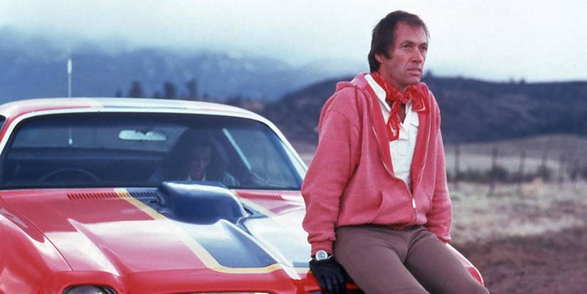 David Carradine sitting in the hood of a car in 'Cannonball' (1976)