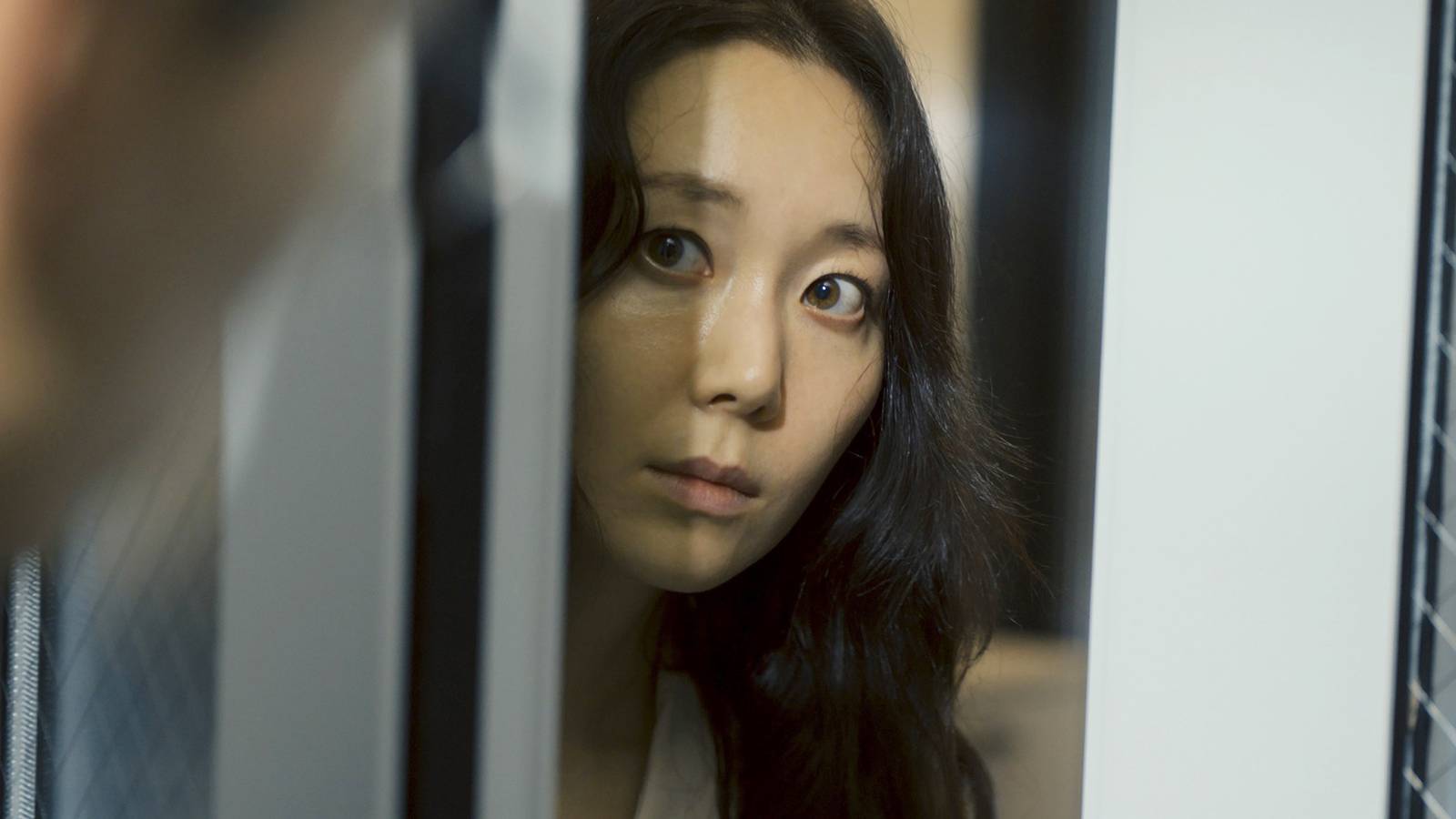 Lee Yoo-Young looking out of a door in Dr. Brain