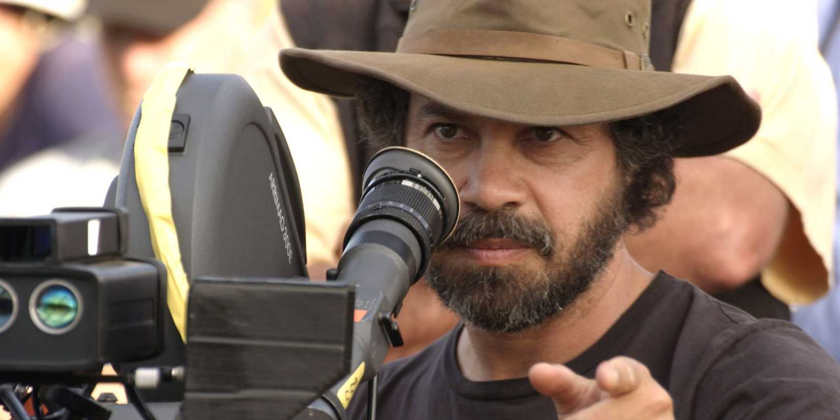 Director Edward Zwick by a camera pointing ahead on the set of The Last Samurai.