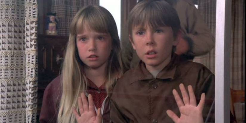 Ike Eisenmann as Tony and Kim Richards as Tia look out a window with trepidation in Escape to Witch Mountain.