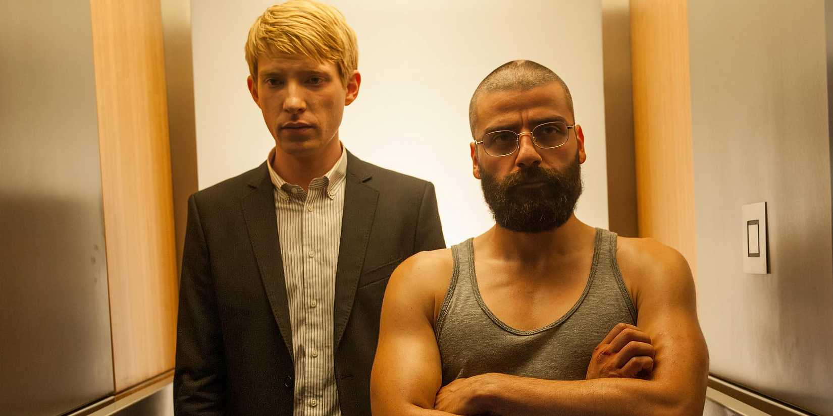 Domhnall Gleeson and Oscar Isaac as Caleb and Nathan stand in a tight hallway in Ex Machina.