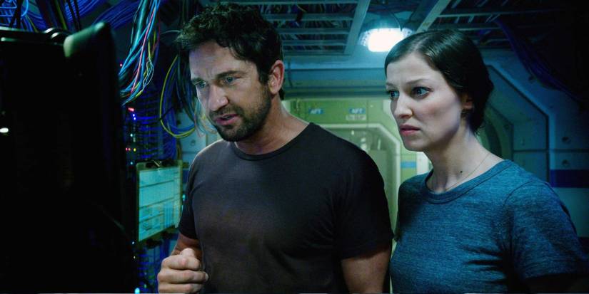 Two people looking at a screen on a space station