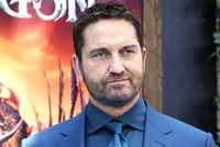 Gerard Butler wears a blue tux at a red carpet event.