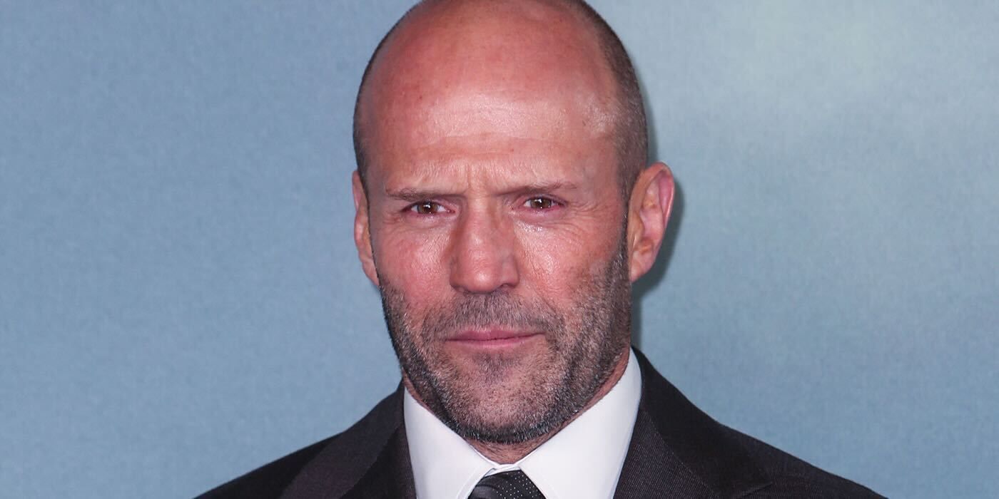 Jason Statham looking directly at the camera against a plain blue background