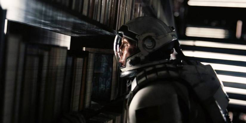 Cooper (Matthew McConaughey) looking through his bookshelf in the 5th dimension in 'Interstellar'