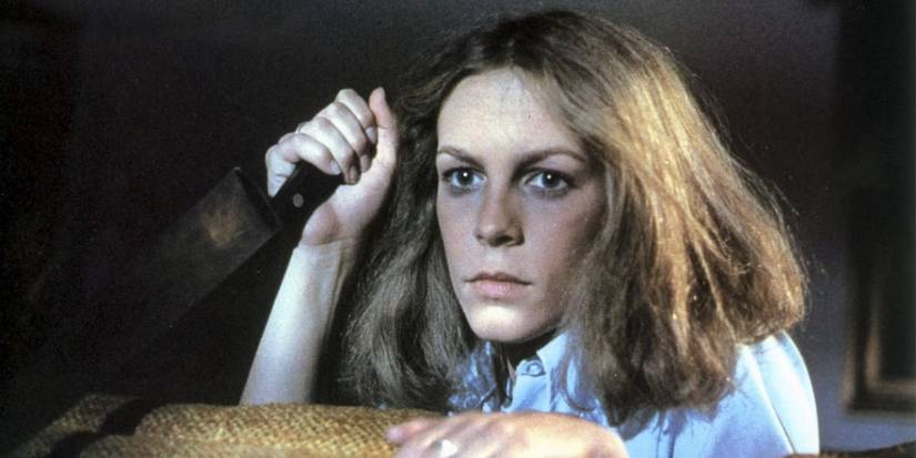 Laurie Strode holding a knife and looking scared in Halloween (1978).