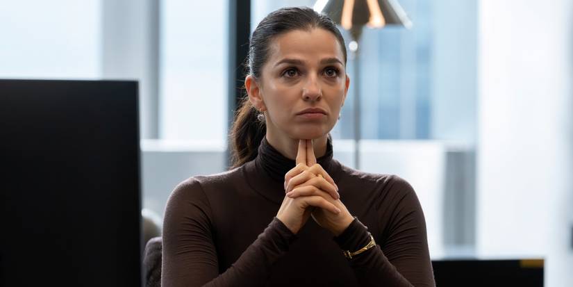 Marisa Abela as Yasmin Kara-Hanani at her desk with both index fingers under her chin in Industry Season 4