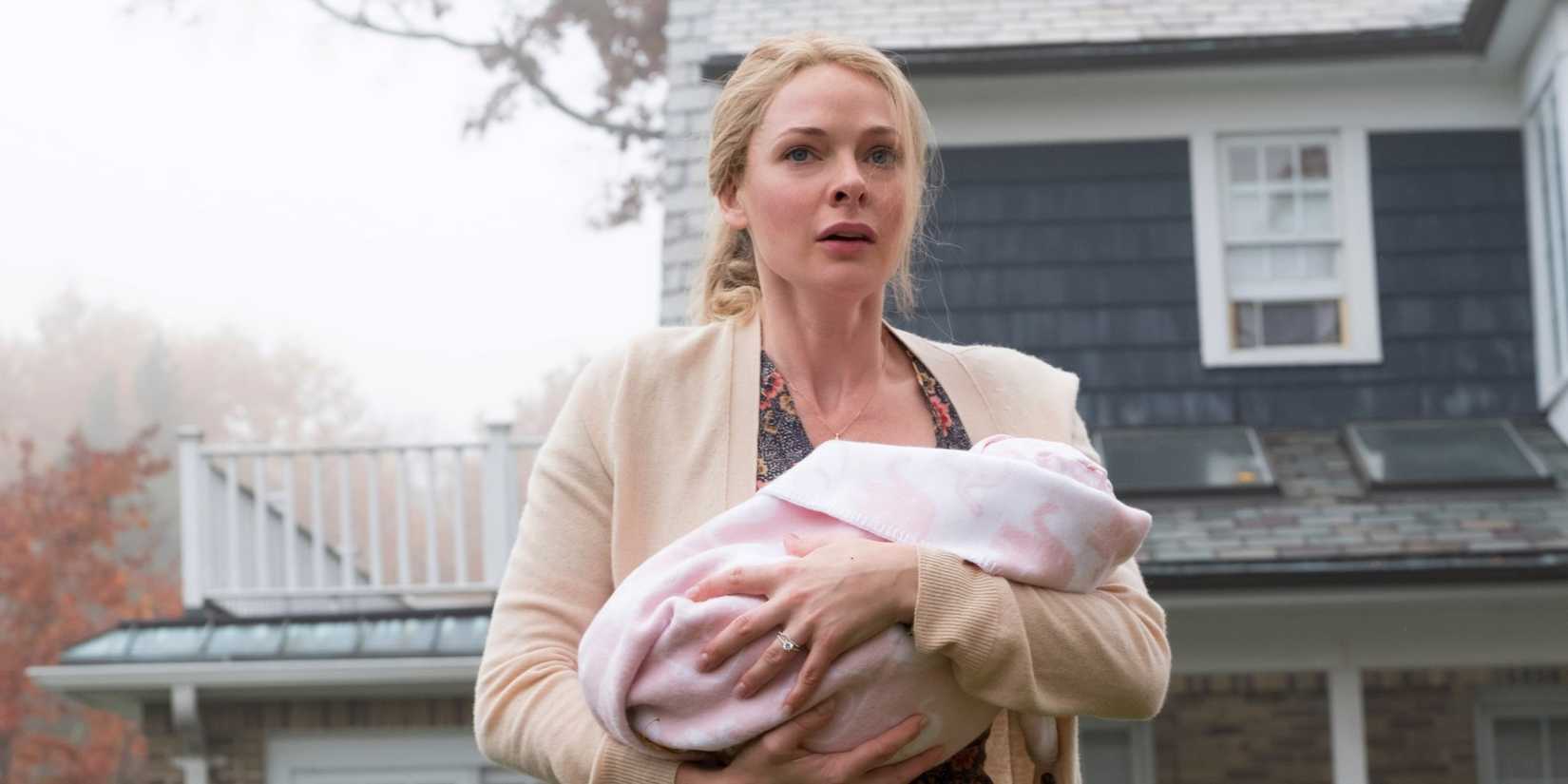 Rebecca Ferguson scared outside her home, holding her baby, in Girl on the Train
