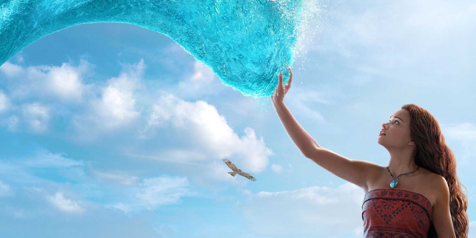 Catherine Laga'aia as Moana touching a wave with an eagle flying in the background in Moana, 2026.