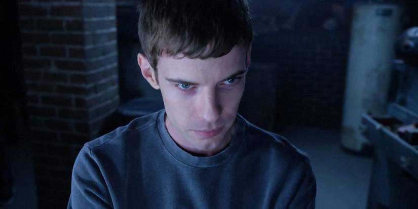 Harry Treadaway in a basement with a sly smile